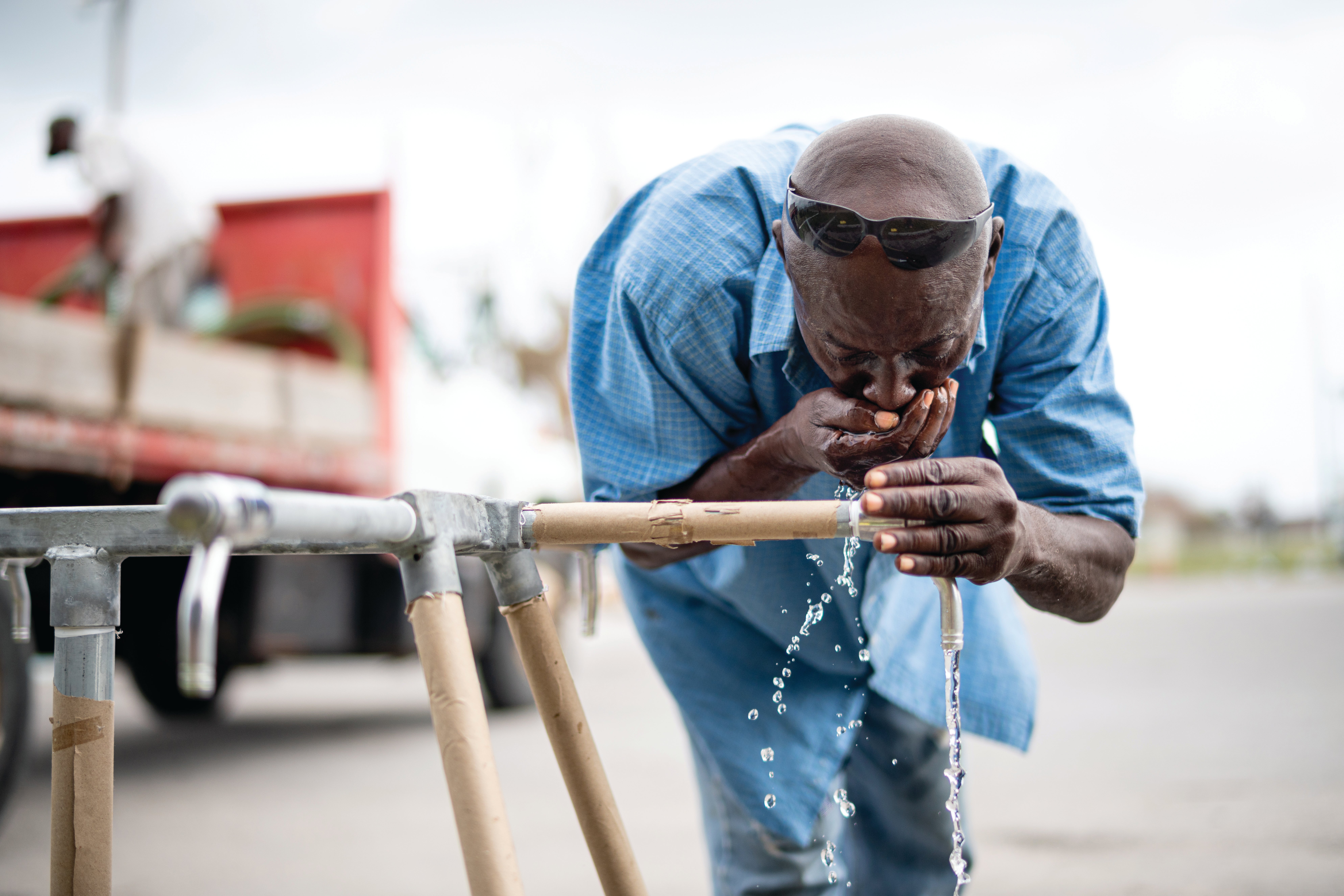 Man drinking from water spigot.