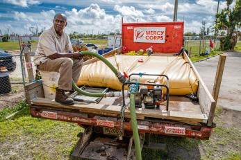 Prosper Global volunteer sitting on water truck in the Bahamas after Hurricane Dorian.