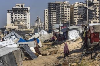 A woman walks between tents in Gaza City.