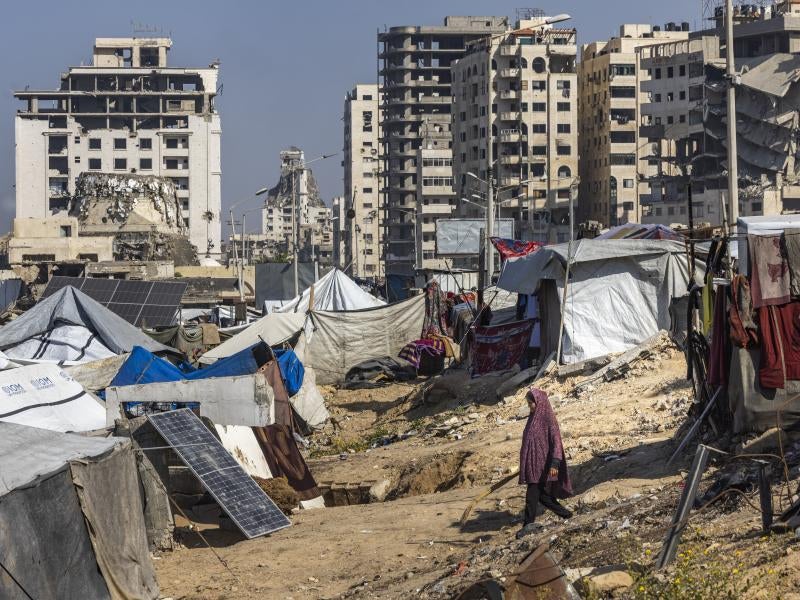 A woman walks between tents in Gaza City.