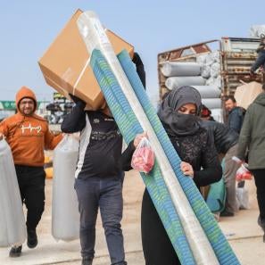 A woman in northwest syria carries emergency kits delivered by prosper global.