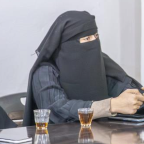 Two syrian woman site at a table in a meeting atmosphere.