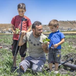 Father and sons engaging and smiling in the middle of their farm.