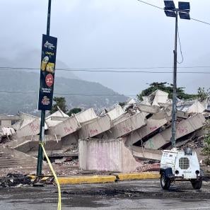 Collapsed building in venezuela with portable lighting in the foreground; this damage is due to major earthquakes that struck the country in june 2026.