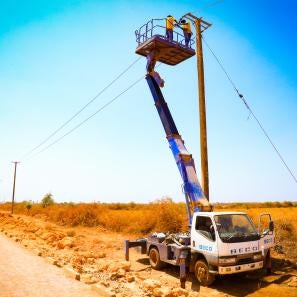 Electrification crew on lift-truck installing power lines outside barwaaqo idp settlement.