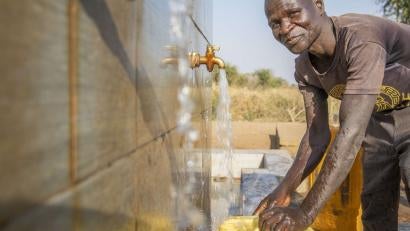 A person filling a jerry can with water.