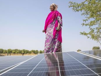 A person standing next to a solar panel.